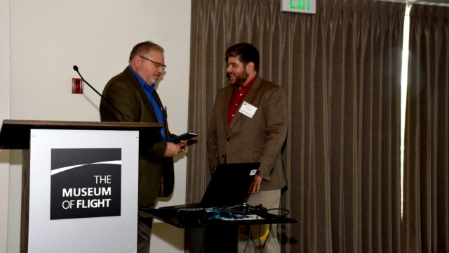 Mark Malone, Boeing Physicist and Associate Tech Fellow, is being thanked by Kevin Welch, Event Chairman, for his presentation on using image processing and recognition software to automatically extract flow data from flow cone video, which both reduces the time required for data reduction following flight and allows for better data fidelity.