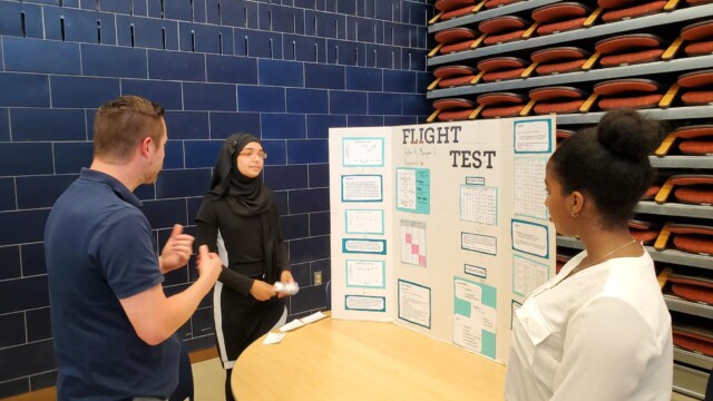 Flight Test Engineer Brian Jones discusses test results with students from Raisbeck Aviation High School.
